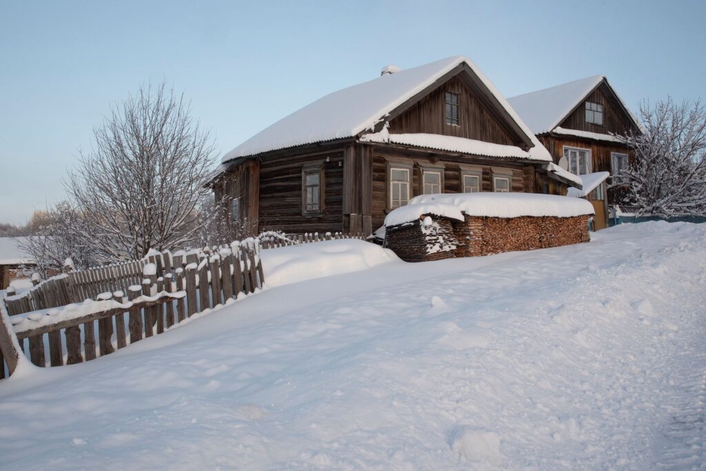 Why Hiring a Professional Snow Removal Company Is a Smart Choice This Winter Rustic wooden cabins surrounded by snow and frost on a winter day